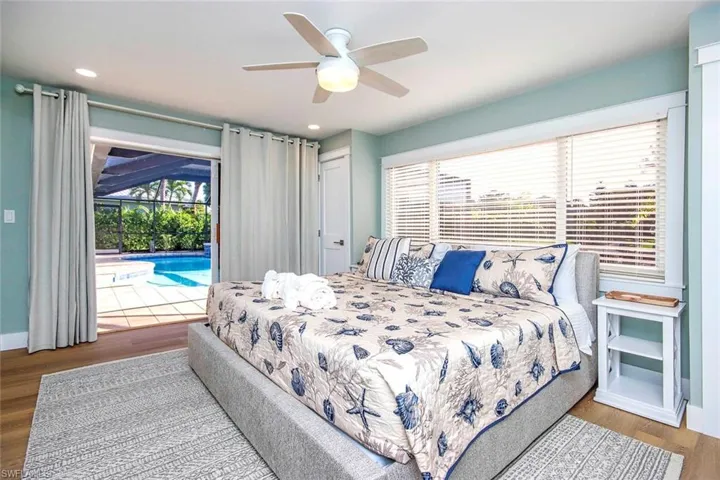 Bedroom featuring wood finished floors, access to exterior, a ceiling fan, and recessed lighting