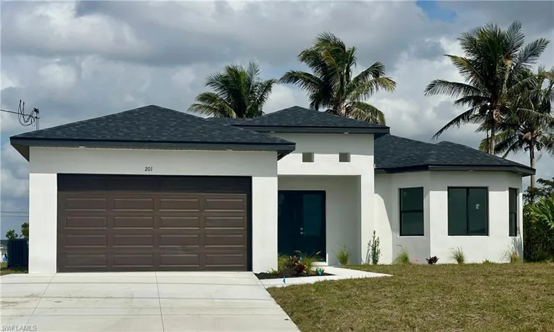 View of front of house with a garage, roof with shingles, a front lawn, and stucco siding