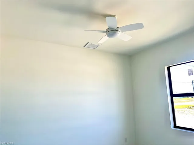 Empty room with ceiling fan and visible vents