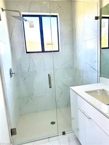 Full bathroom featuring vanity and a marble finish shower