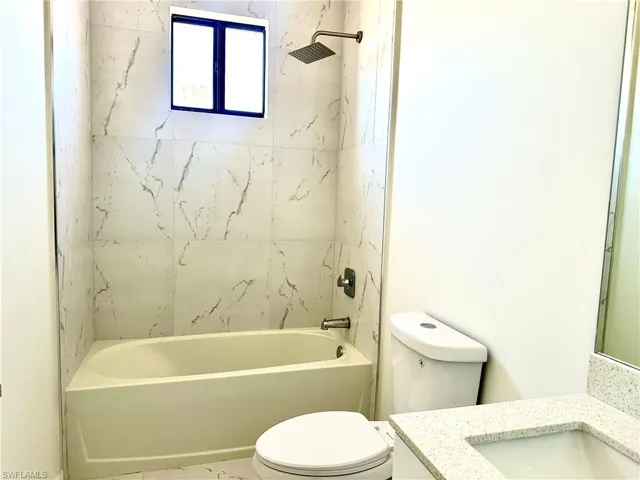 Bathroom featuring shower / tub combination, vanity, and toilet
