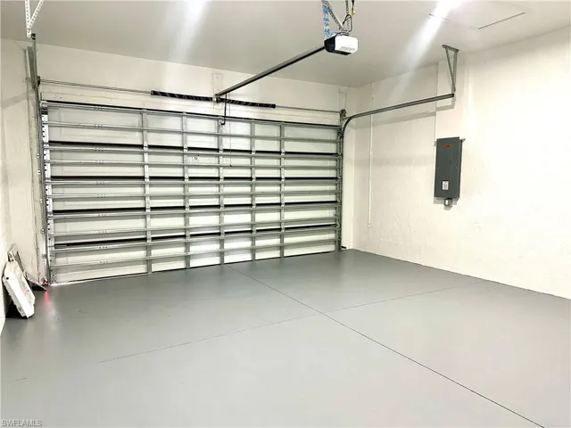 Garage featuring electric panel and a garage door opener