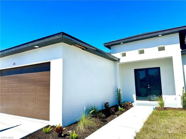Entrance to property featuring a garage, french doors, and stucco siding