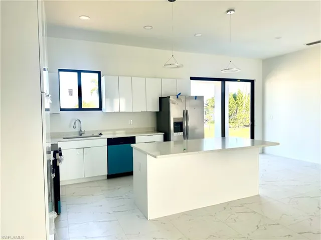 Kitchen with dishwashing machine, a sink, visible vents, marble finish floor, and stainless steel refrigerator with ice dispenser