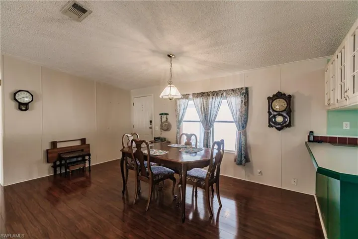 Dining area featuring ornamental molding, dark hardwood / wood-style floors, and a textured ceiling