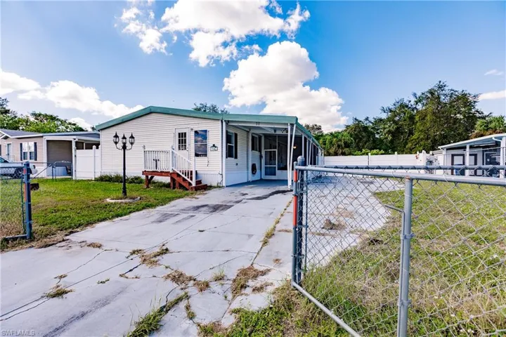 Manufactured / mobile home with a front yard and a carport