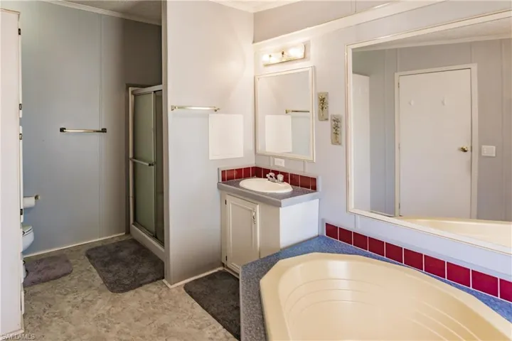 Bathroom with vanity, a shower with door, and ornamental molding
