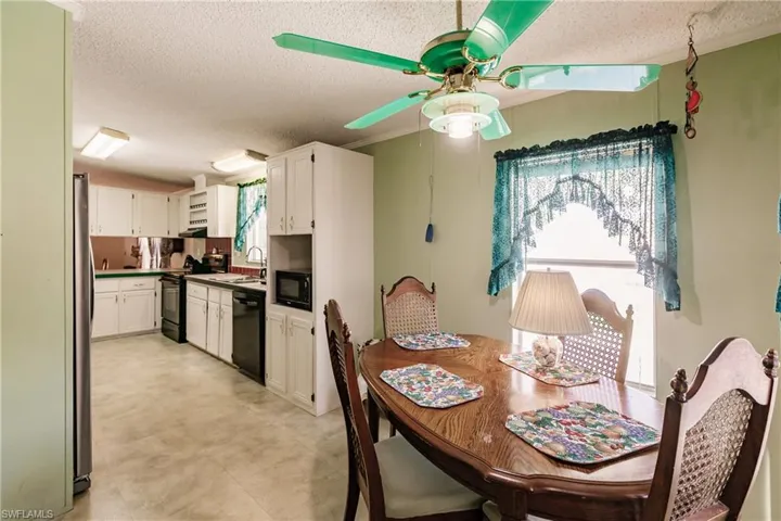 Dining space featuring ceiling fan, sink, and a textured ceiling