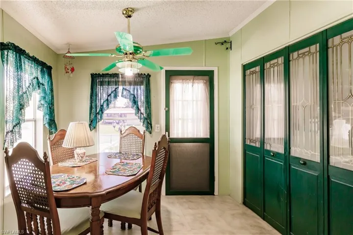 Dining area with ceiling fan, crown molding, a healthy amount of sunlight, and a textured ceiling