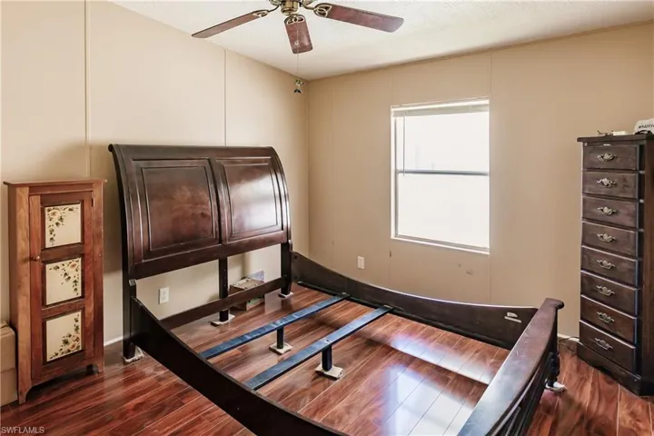 Bedroom featuring a textured ceiling, ceiling fan, and dark hardwood / wood-style floors
