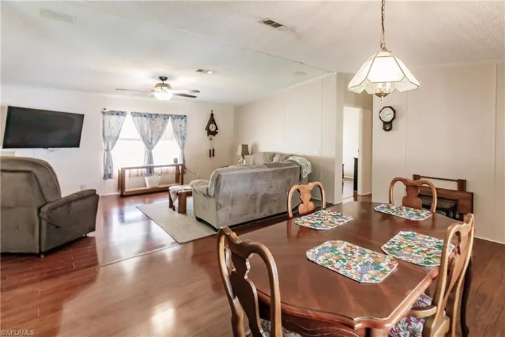 Dining room with ceiling fan, dark wood-type flooring, and a textured ceiling