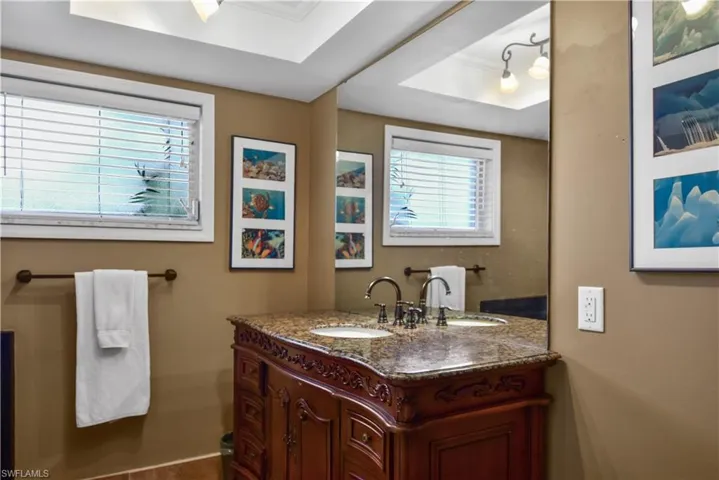Guest bathroom featuring granite vanity and shower/tub combo