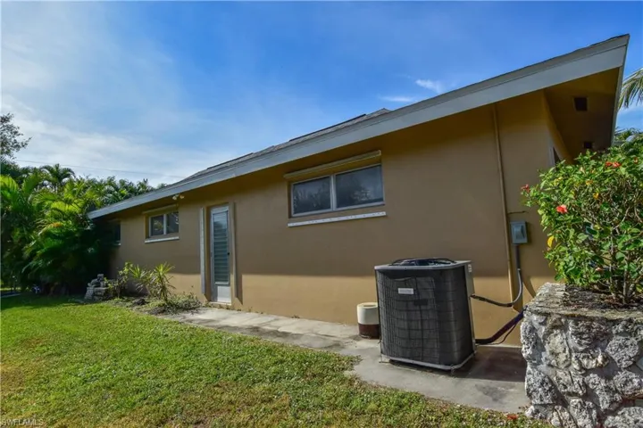 Side of home with side door leading to garage.