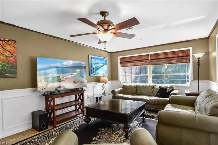 Great room offering a wealth of natural light, ornamental molding, and ceiling fan