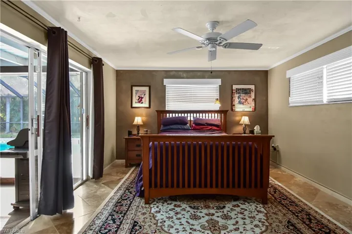 Spacious primary bedroom with access to the lanai and crown molding