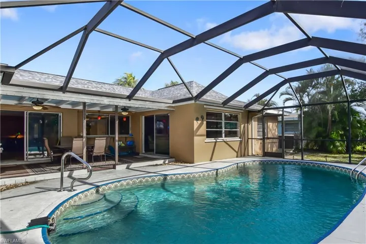 View of swimming pool featuring large enclosed lanai.