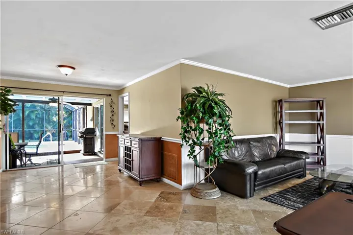 Formal living room with crown molding, chair rail and Travertine flooring.