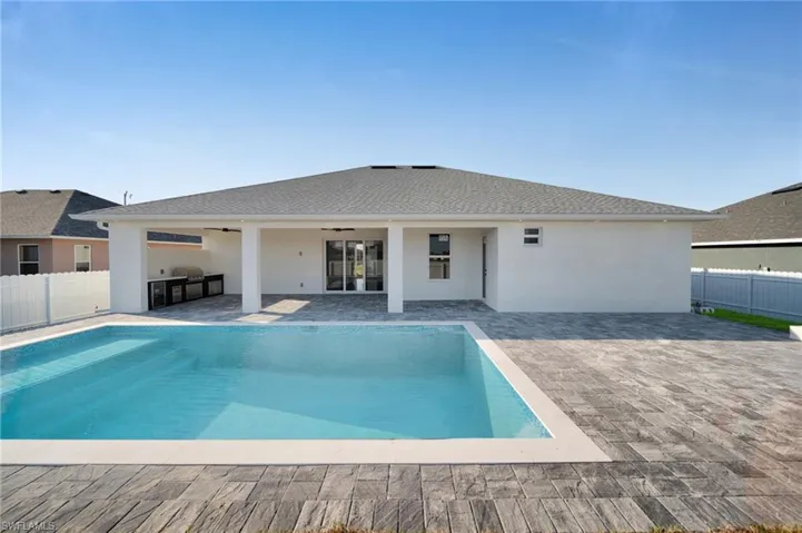 View of swimming pool featuring ceiling fan, a patio area, and fence