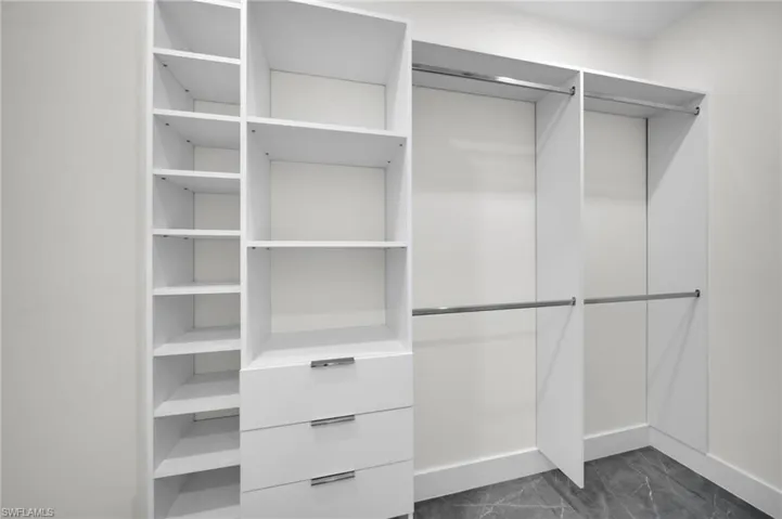Walk in closet featuring marble finish floor