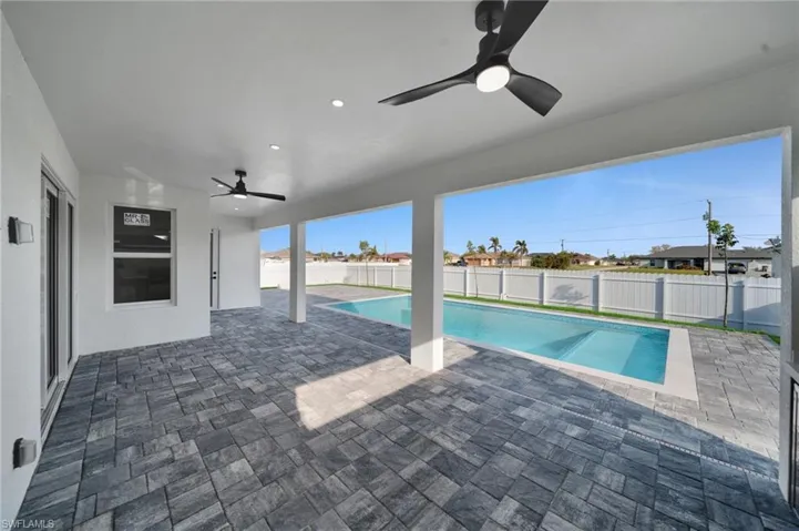 View of pool with a fenced backyard, ceiling fan, and a patio