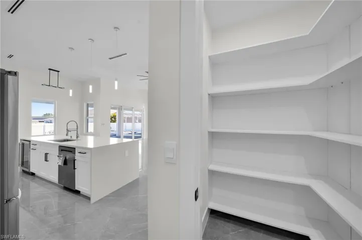 Storage area with wine cooler, visible vents, and a sink