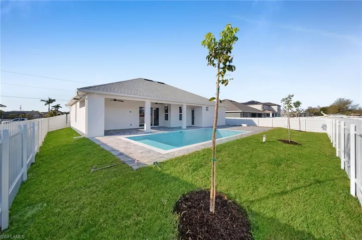 Back of house with a fenced backyard, a patio, a ceiling fan, and a yard