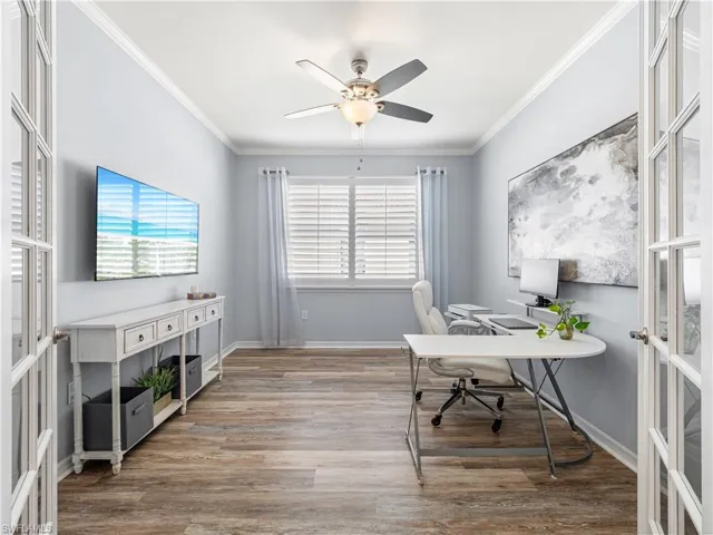 Office space with light wood finished floors, crown molding, ceiling fan, and french doors