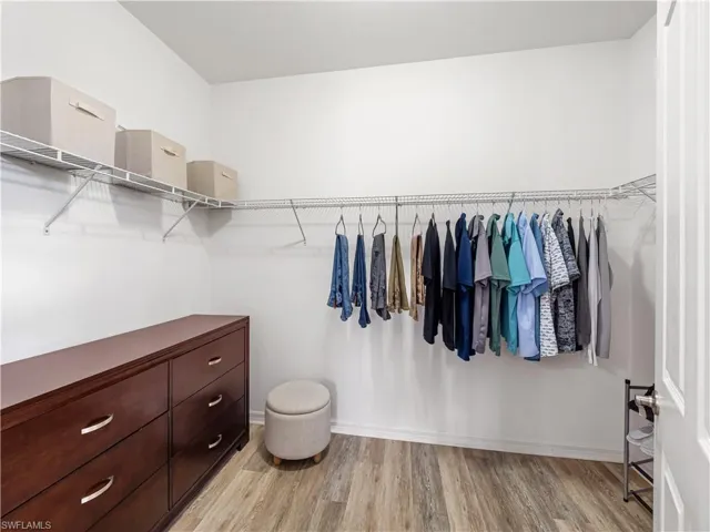 Walk in closet with light wood-type flooring