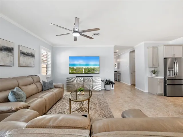 Living room with ornamental molding and a ceiling fan
