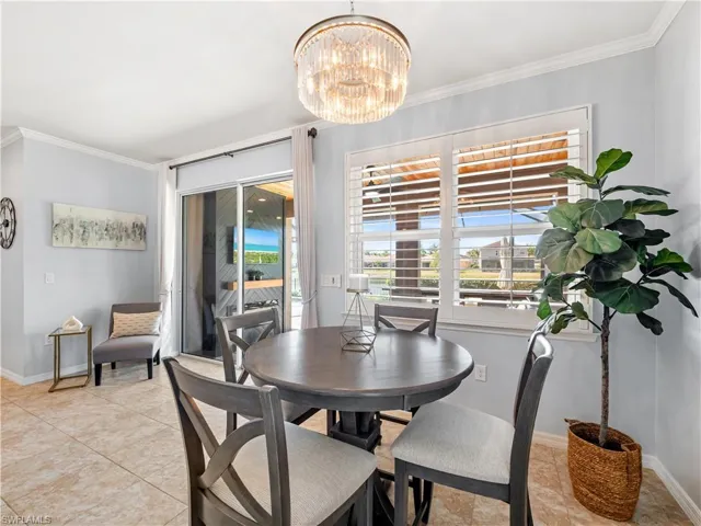 Dining area with ornamental molding and a chandelier