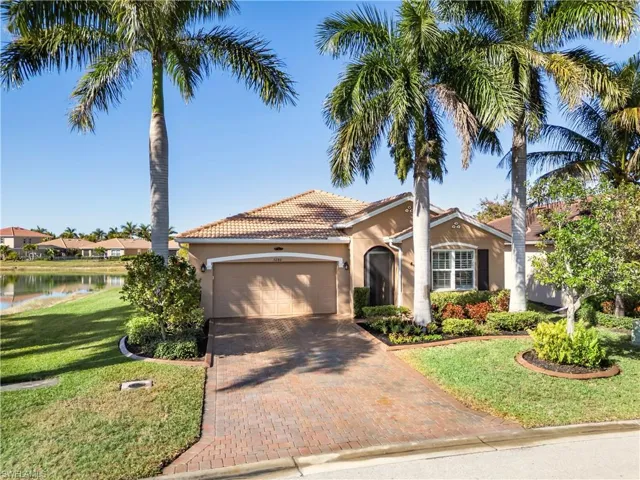 Mediterranean / spanish house featuring stucco siding, decorative driveway, a garage, a front yard, and a tile roof