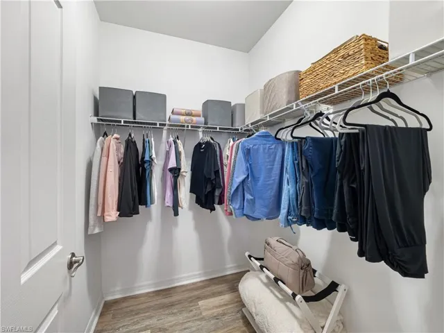 Walk in closet with light wood-type flooring