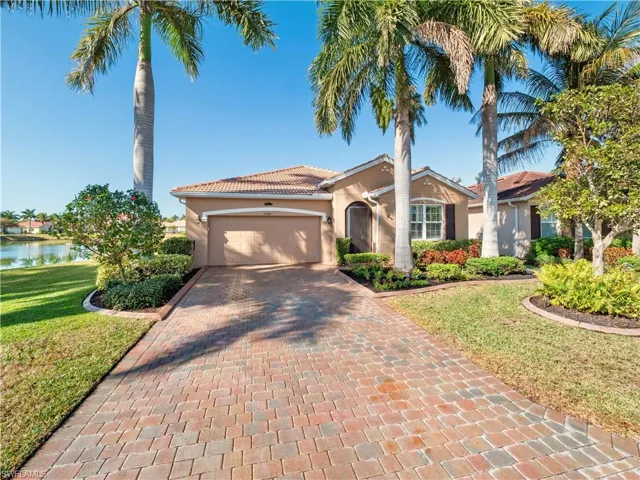 Mediterranean / spanish-style house with stucco siding, decorative driveway, a front yard, and a garage