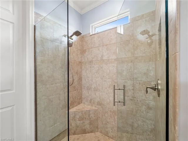 Full bathroom featuring a shower stall and ornamental molding