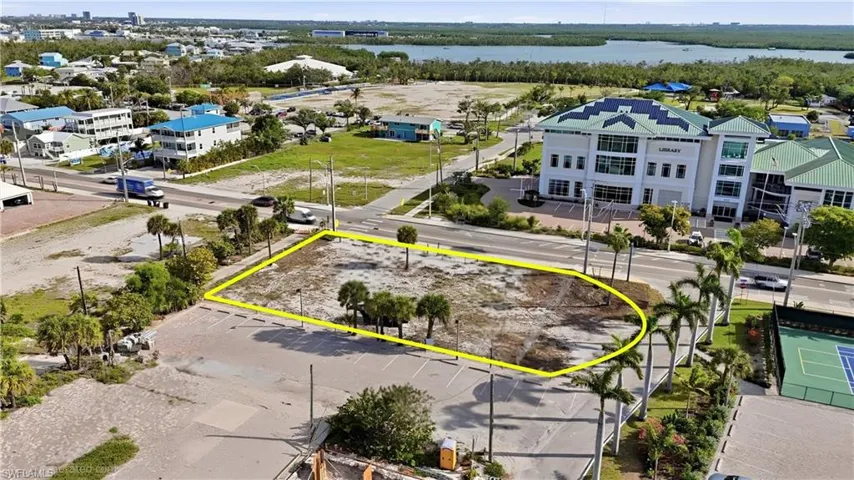 Cleared land parcel featuring mature palm trees and direct road frontage - Virtually Edited Image