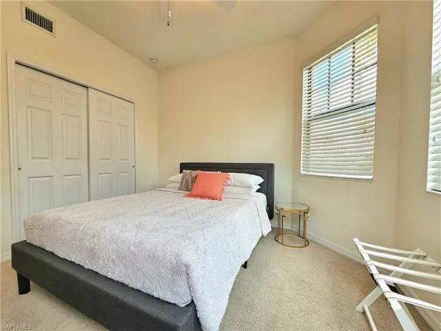 Bedroom with a closet, ceiling fan, carpet floors, baseboards, and visible vents