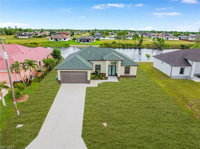 View of front of home featuring driveway, a residential view, and a water view