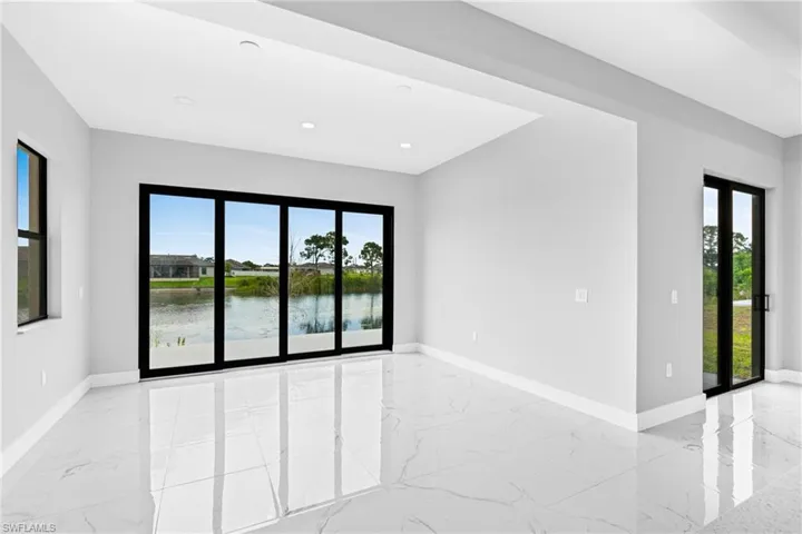 Unfurnished room with a water view, light marble finish flooring, and recessed lighting