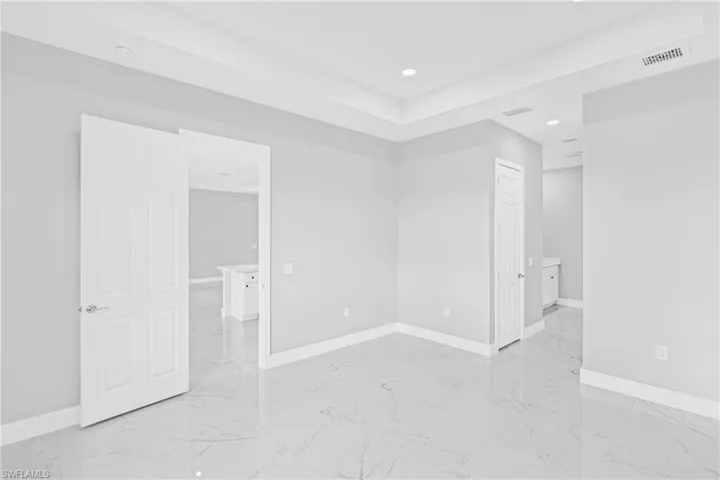 Unfurnished bedroom featuring light marble finish floors, recessed lighting, and a closet