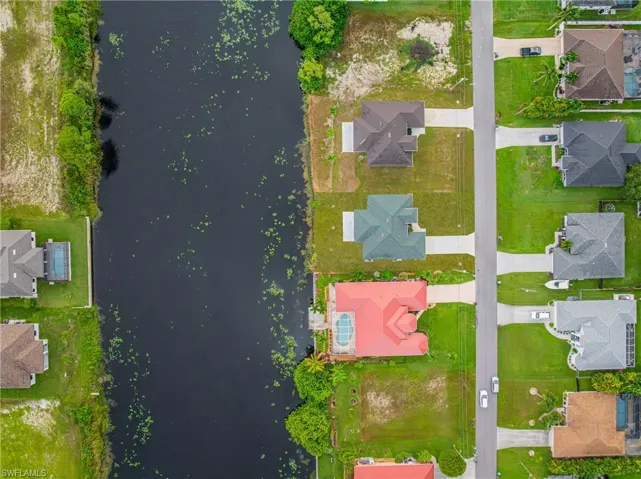 Aerial perspective of suburban area featuring a large body of water