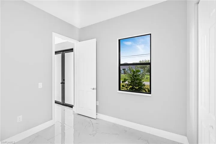 Spare room featuring baseboards and light marble finish flooring