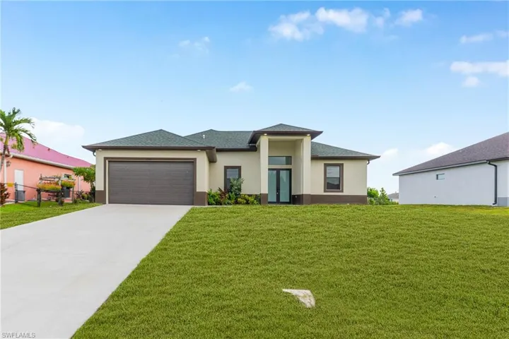 Prairie-style home featuring a front lawn, stucco siding, concrete driveway, an attached garage, and roof with shingles