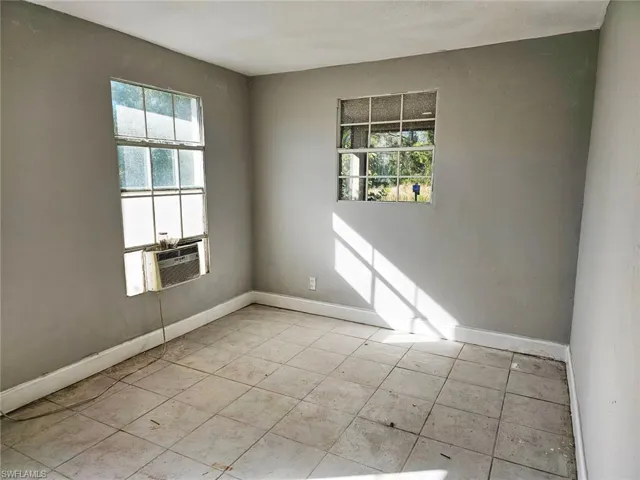 Spare room featuring light tile patterned floors and cooling unit