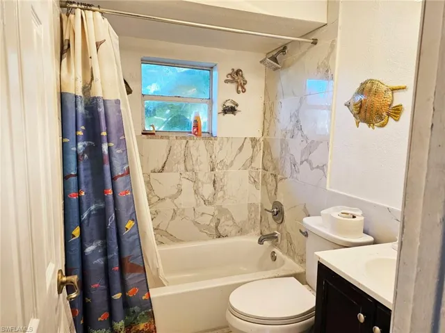 Full bathroom featuring shower / tub combo with curtain and vanity