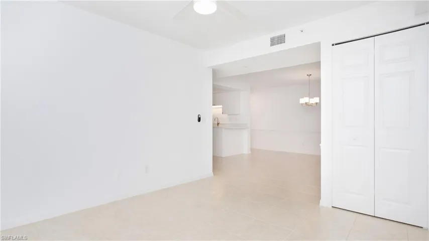 Den/office featuring a chandelier, a ceiling fan, light tile patterned flooring, closet and baseboards