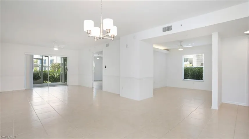 Family room with a chandelier, light tile patterned flooring, a ceiling fan, and baseboards
