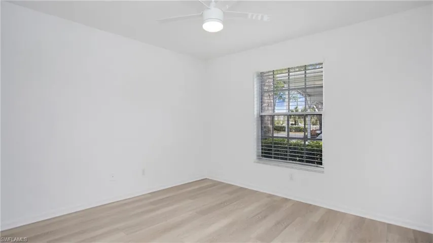 Front bedroom with light wood finished floors, baseboards, and a ceiling fan
