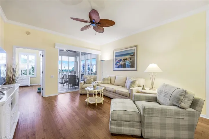 Living room featuring ceiling fan, ornamental molding, and hardwood / wood-style flooring