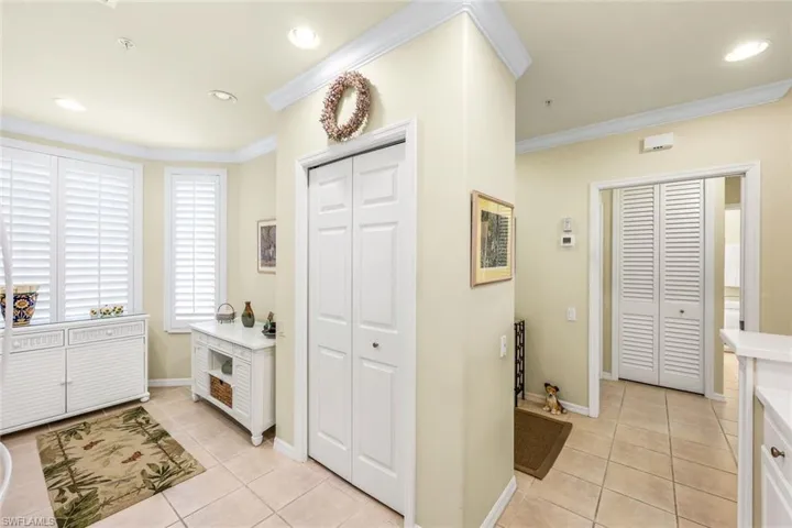 Tiled foyer featuring crown molding