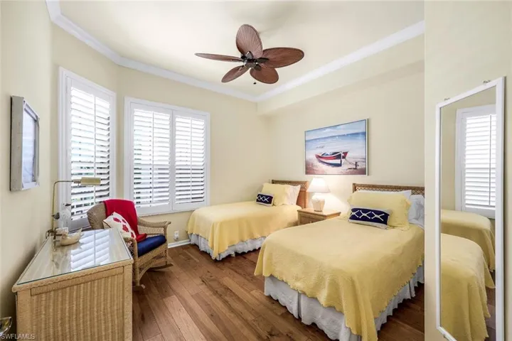 Bedroom with crown molding, hardwood / wood-style floors, and ceiling fan